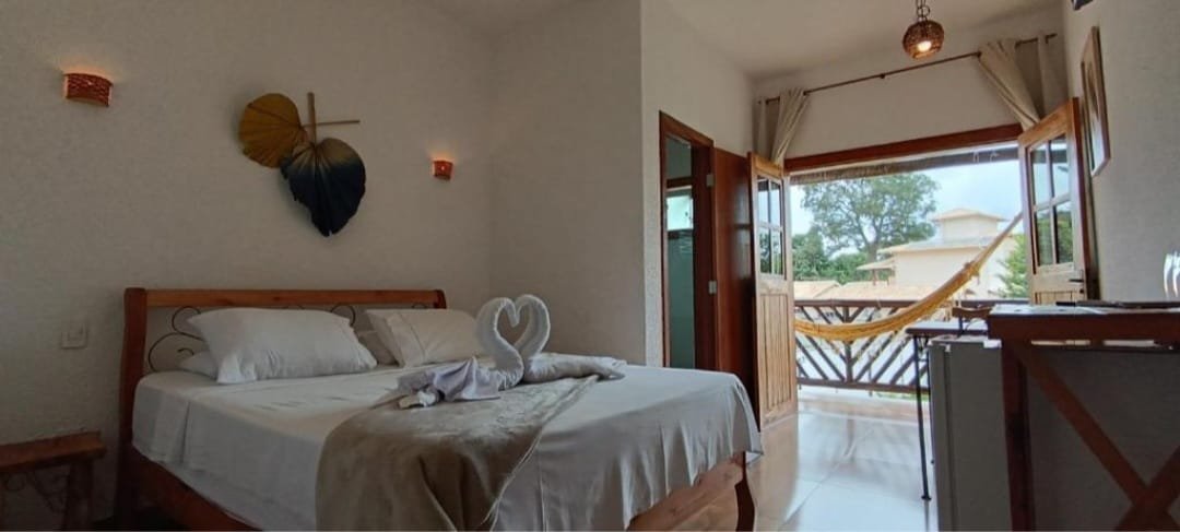 Suite com cama de casal, varanda e rede